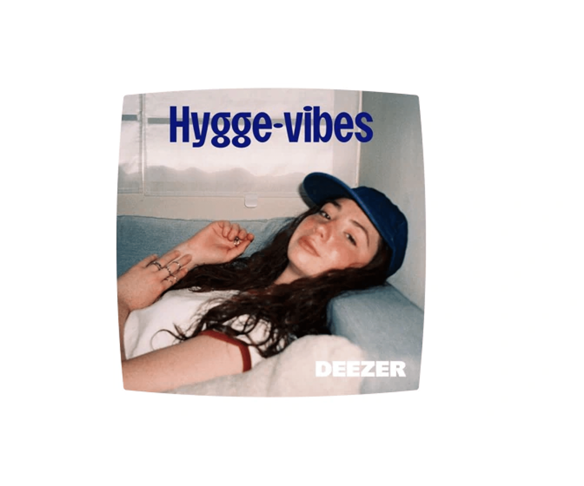 Kvinde ligger afslappet i en sofa med teksten “Hygge-vibes” og Deezer-logoet på billedet.