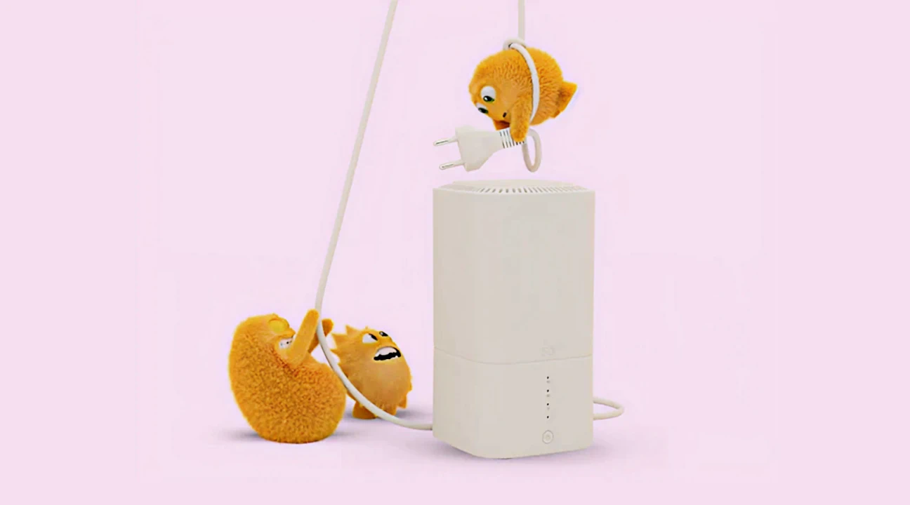 Små Priser sidder ved en hvid router med stik og kabler på lyserød baggrund.
