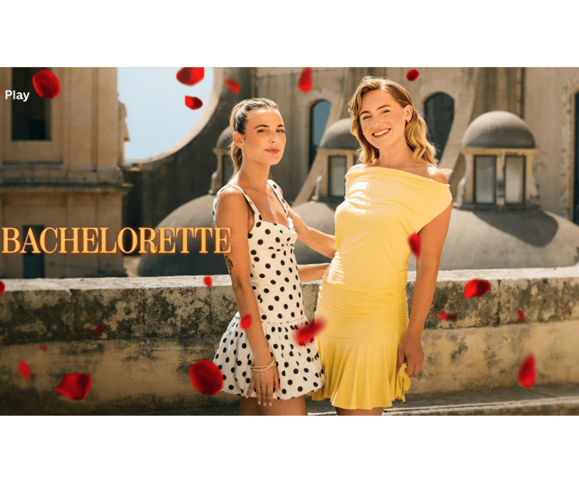 To kvinder står udendørs i sollys foran en bygning, mens røde rosenblade daler ned omkring dem. Teksten “Bachelorette” og TV 2 Play-logo ses i billedet.