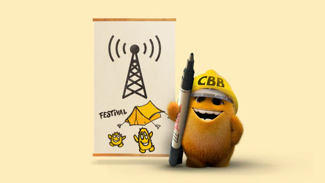 Små Pris ved en festivalplakat med en teles mast, telt og teksten Festival, mens den holder en tusch foran sig.