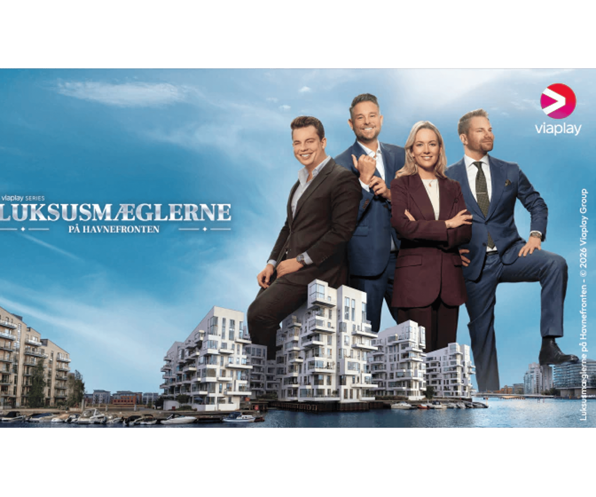 Fire personer står foran moderne havneboliger med Viaplay-logo og titlen Luksusmæglerne på havnefronten.