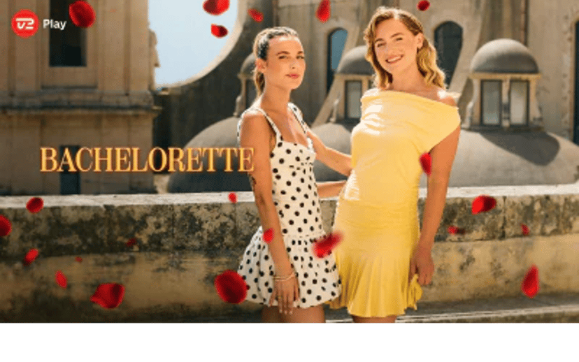To kvinder poserer på en tagterrasse omgivet af røde rosenblade med Bachelorette-logoet i øverste venstre hjørne.