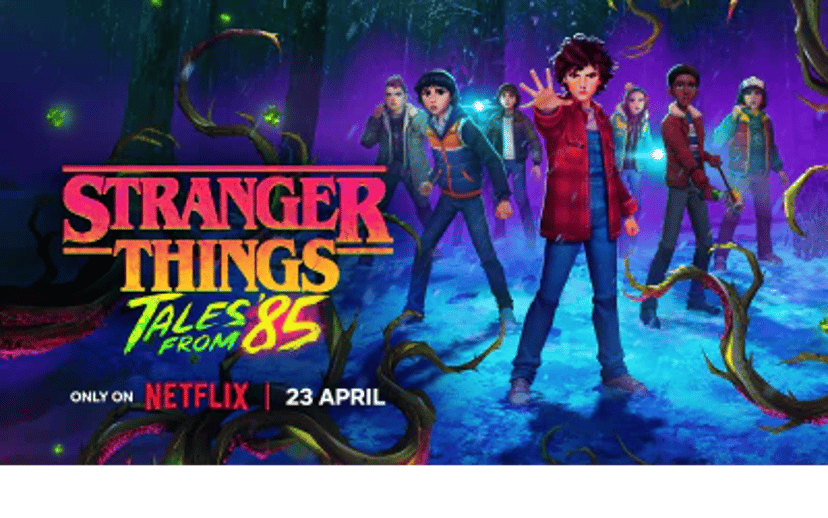 Stranger Things-plakat med de unge hovedpersoner foran en mørk skov og neonfarvede effekter. Teksten “Tales From ’85” og Netflix-logoet står nederst.