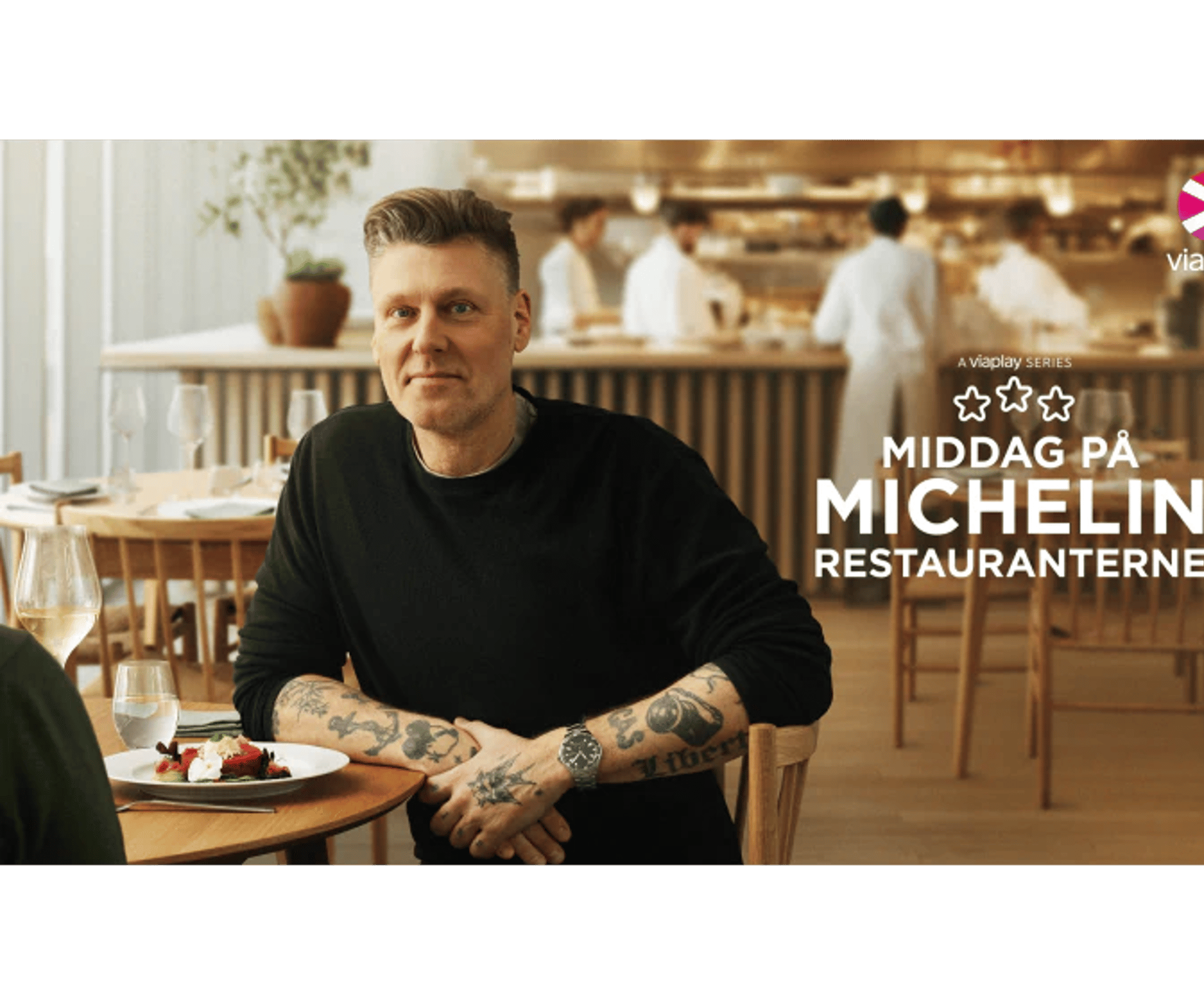 Viaplay-serie med en mand ved et restaurantbord i en Michelin-restaurant med lyse træmøbler og personale i baggrunden.