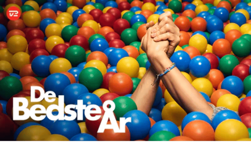 Farverige bolde fylder billedet, mens to hænder er løftet og holdt sammen i midten. Nederst står teksten "De Bedste År" sammen med TV 2 Play-logoet og CBB MIX-logoet.