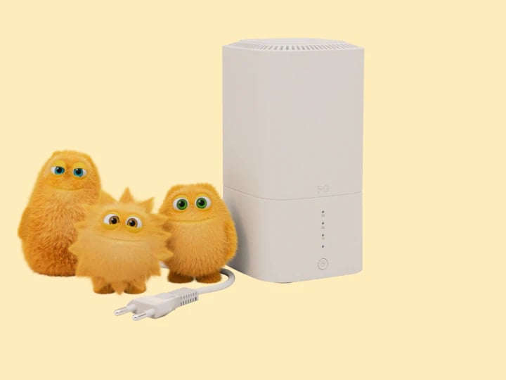 En hvid 5G-internetenhed er placeret på en gul baggrund sammen med tre små, lodne gule figurer med store øjne. Enheden er tilsluttet med et synligt hvidt kabel.