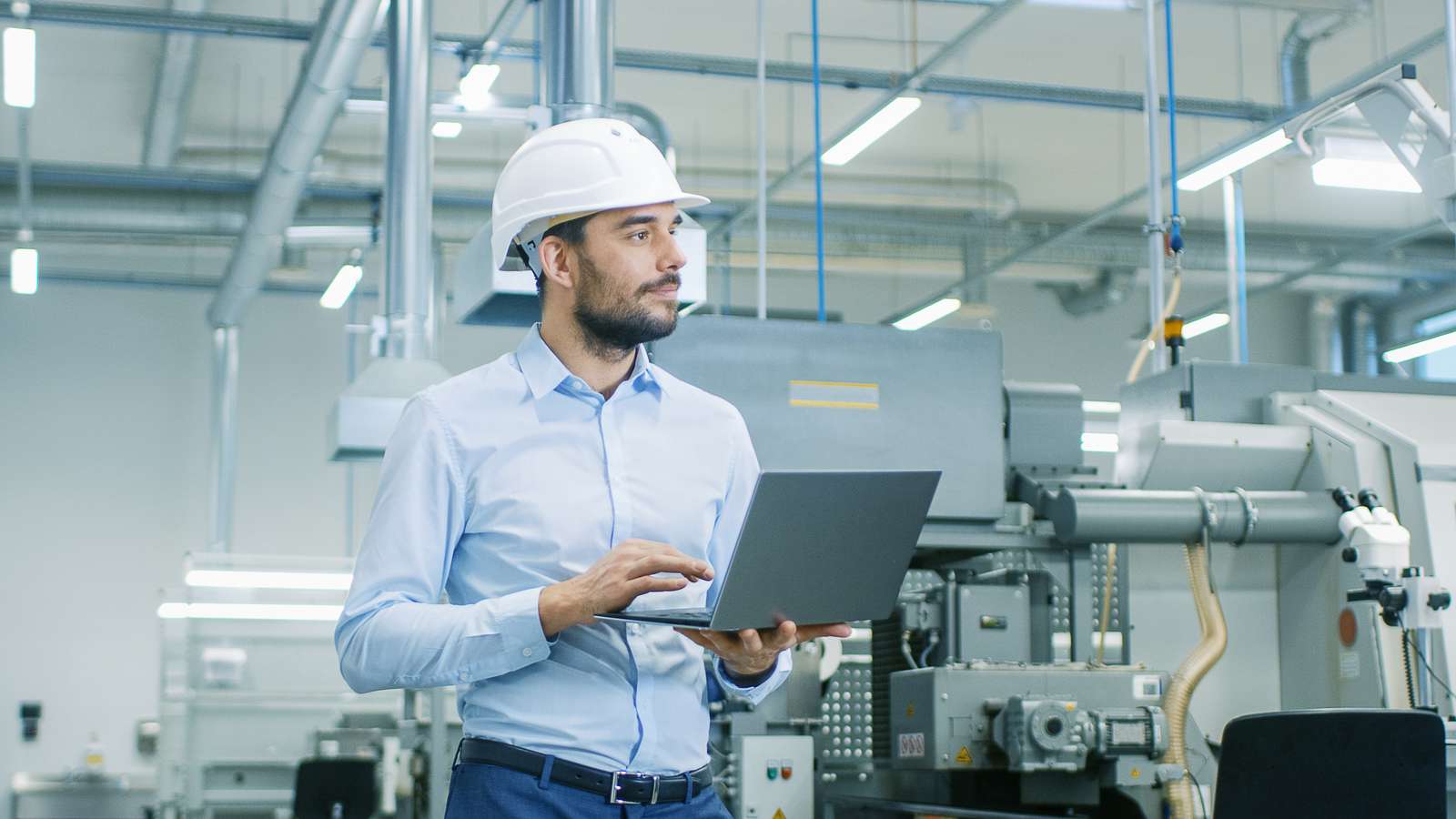 Engineer using laptop in a factory