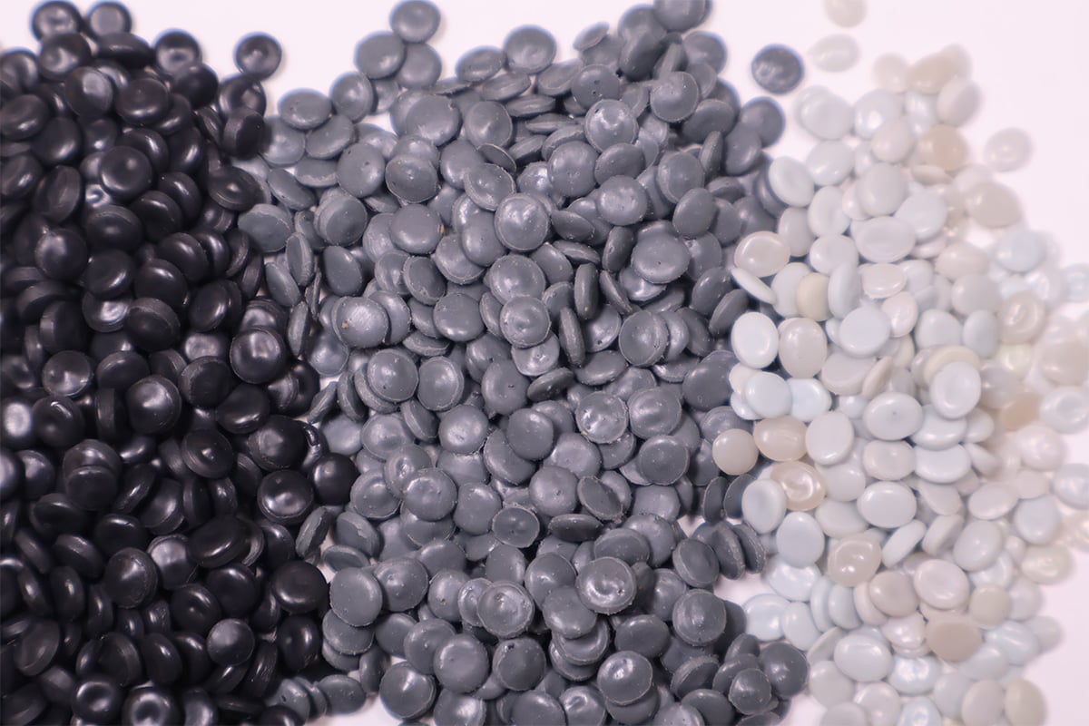 Plastic pellets in black, gray, and white